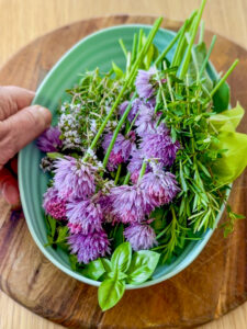 a bowl of flowers and herbs